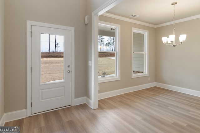 entryway featuring baseboards, visible vents, ornamental molding, an inviting chandelier, and light wood-style floors