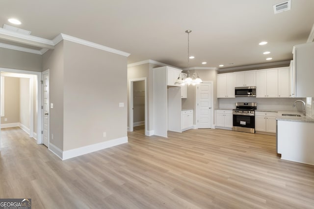 kitchen with light wood-type flooring, visible vents, stainless steel appliances, and a sink