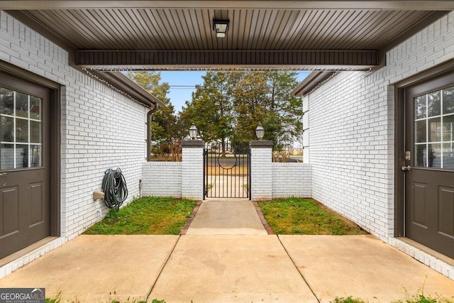 exterior space featuring a gate, brick siding, and fence