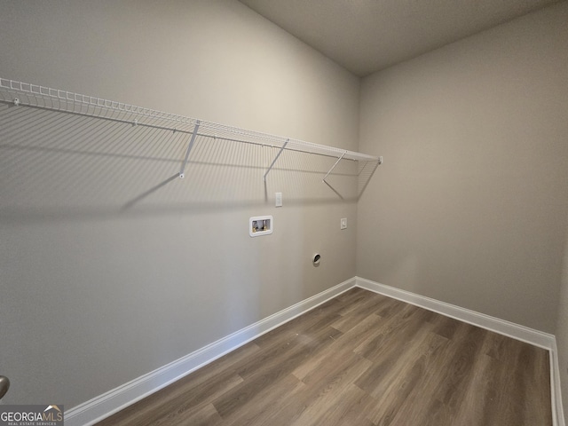 laundry area featuring laundry area, baseboards, dark wood finished floors, hookup for an electric dryer, and washer hookup