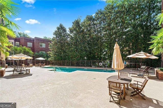 pool featuring a patio area and fence