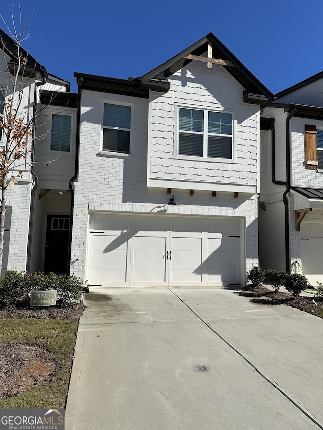 view of front facade featuring driveway, an attached garage, and brick siding