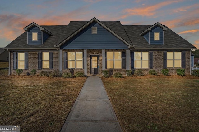 view of front facade featuring brick siding and a front yard