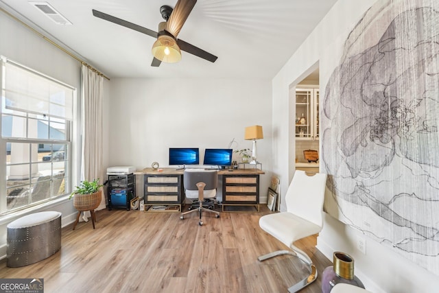 office space with baseboards, ceiling fan, visible vents, and wood finished floors