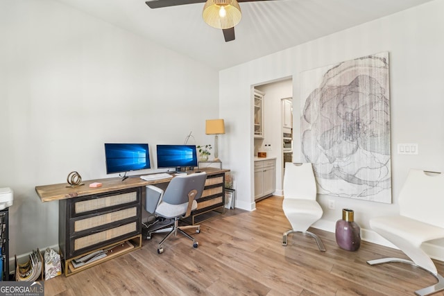 office area with light wood-style floors and ceiling fan