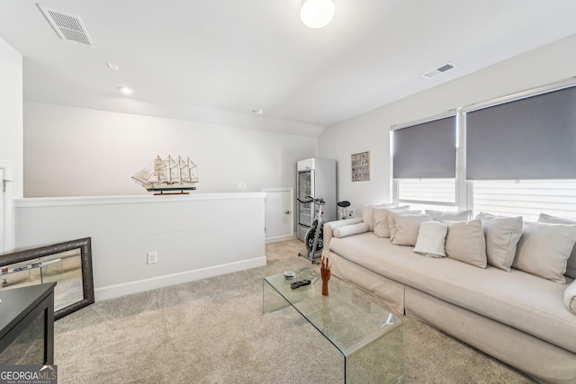 living area with light carpet, baseboards, and visible vents