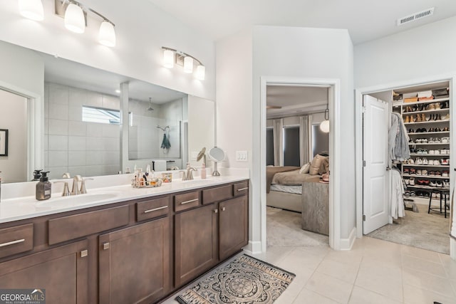 full bath featuring tile patterned flooring, visible vents, a sink, and walk in shower