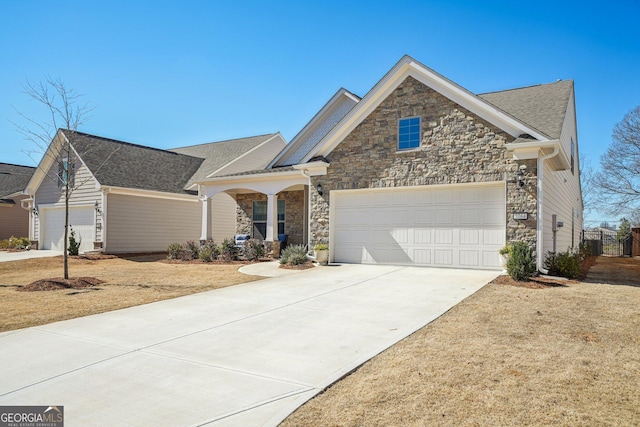 view of front of home with a garage, stone siding, and driveway