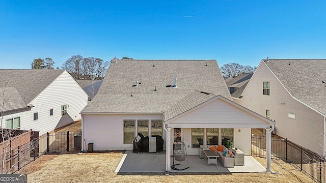 rear view of house with a patio area, outdoor lounge area, a fenced backyard, and roof with shingles