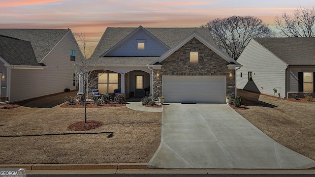 view of front facade with a garage, stone siding, and concrete driveway