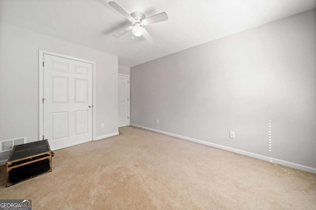 unfurnished bedroom with carpet floors, a ceiling fan, visible vents, and baseboards