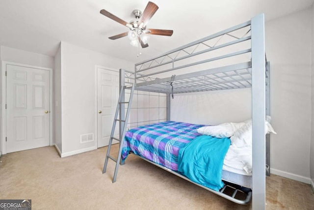 carpeted bedroom featuring baseboards, visible vents, and a ceiling fan