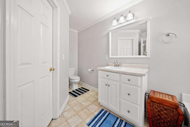 bathroom featuring toilet, vanity, baseboards, ornamental molding, and tile patterned floors