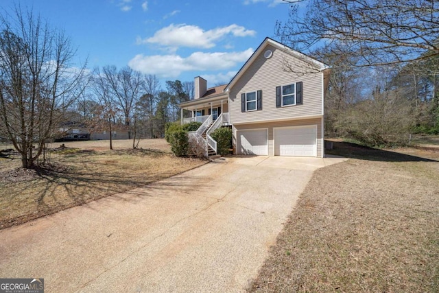 traditional-style home featuring a garage, concrete driveway, a chimney, stairway, and a porch