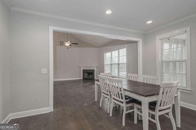 dining space with ornamental molding, dark wood-style flooring, a fireplace, and baseboards