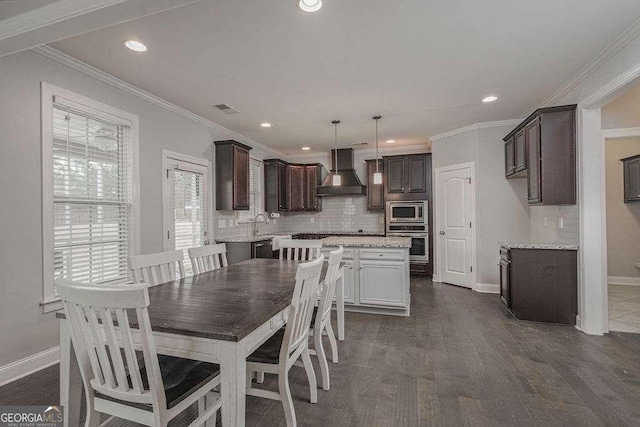 dining room featuring dark wood-style floors, baseboards, visible vents, and crown molding