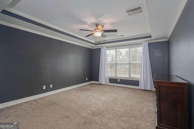 unfurnished room with light carpet, ceiling fan, visible vents, and a tray ceiling