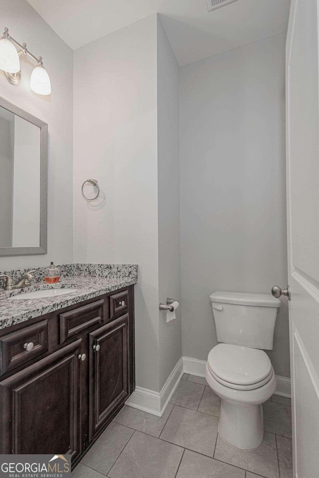 bathroom featuring tile patterned flooring, toilet, visible vents, vanity, and baseboards