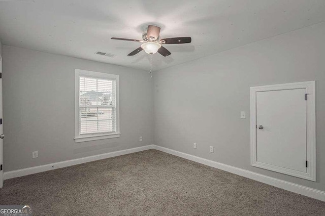 carpeted spare room with ceiling fan, visible vents, and baseboards