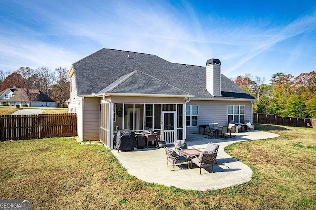 back of house with a fenced backyard, a shingled roof, a sunroom, a yard, and a patio area