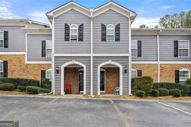 view of front of home featuring uncovered parking and brick siding