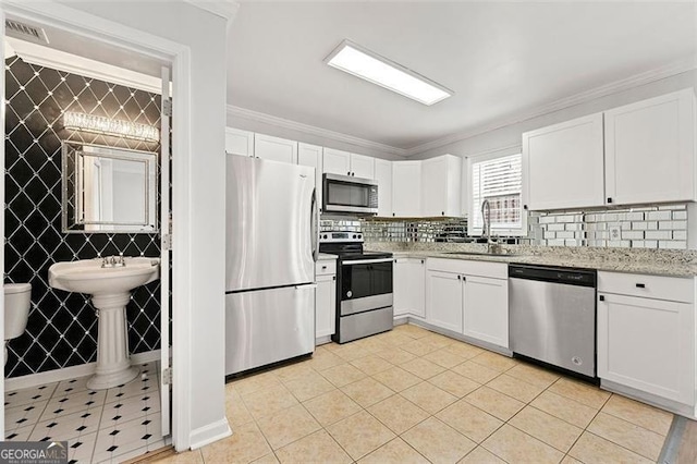 kitchen with crown molding, visible vents, appliances with stainless steel finishes, white cabinetry, and a sink