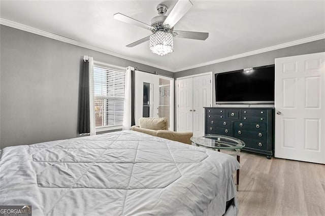 bedroom with ceiling fan, a closet, ornamental molding, and wood finished floors