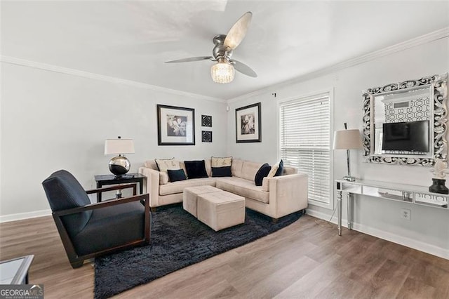 living room featuring baseboards, crown molding, and wood finished floors