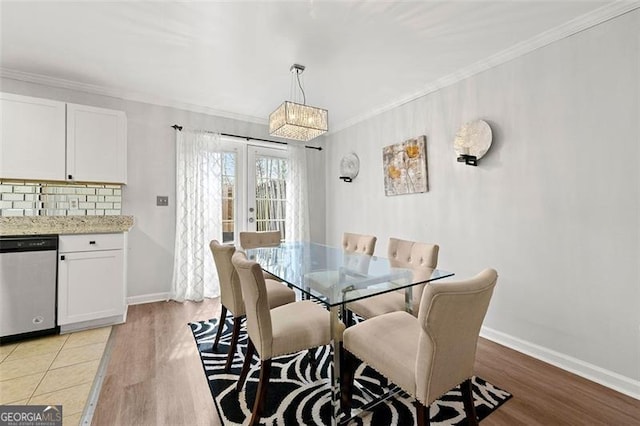 dining area featuring light wood-style floors, baseboards, and crown molding