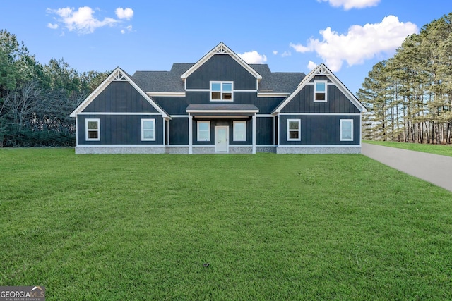 view of front facade with a front yard and roof with shingles