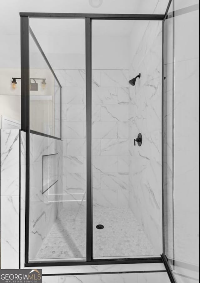 bathroom with a marble finish shower