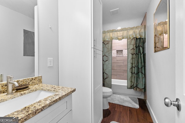 full bathroom with visible vents, toilet, shower / bath combo with shower curtain, vanity, and wood finished floors