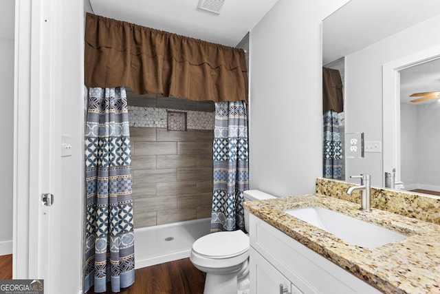 full bathroom featuring toilet, wood finished floors, vanity, visible vents, and a stall shower