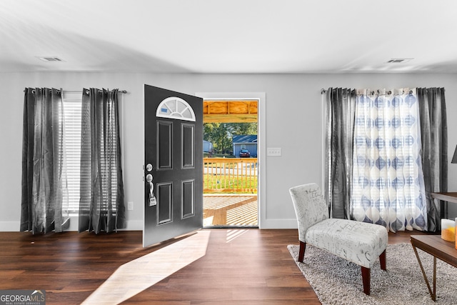 foyer with a wealth of natural light, visible vents, and wood finished floors