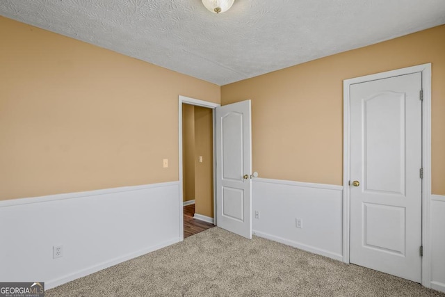 unfurnished bedroom with a textured ceiling and carpet