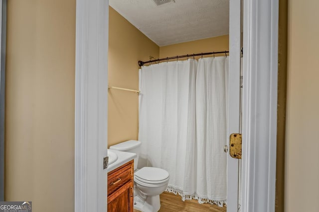 full bath featuring visible vents, toilet, a textured ceiling, vanity, and a shower with curtain