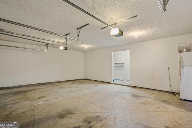 garage with a garage door opener and freestanding refrigerator