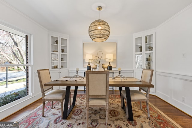 dining room featuring plenty of natural light, wood finished floors, and built in shelves