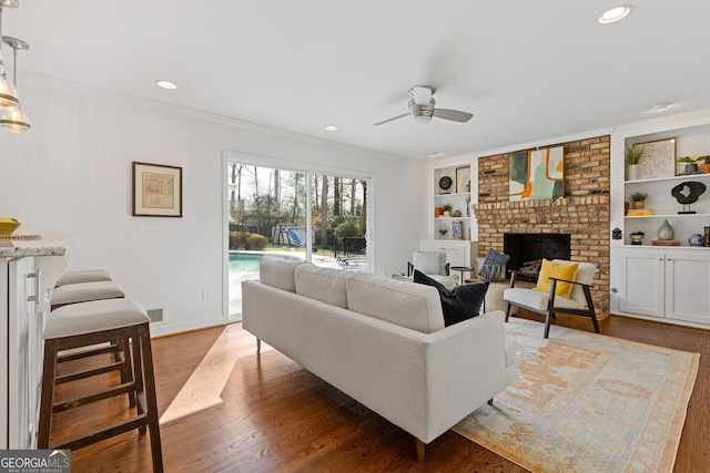 living room featuring visible vents, wood finished floors, ceiling fan, and ornamental molding