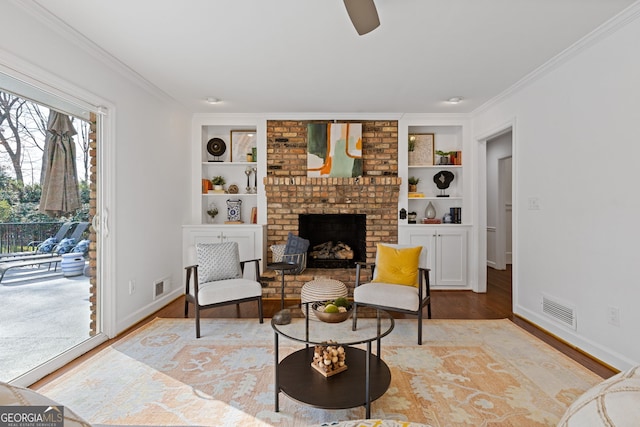 living area featuring crown molding, wood finished floors, and visible vents