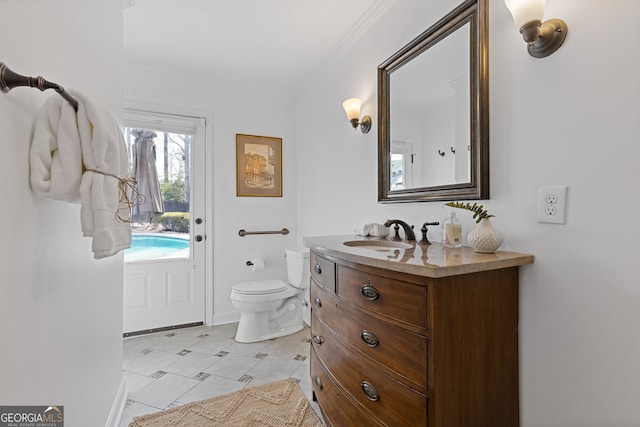 bathroom with vanity, toilet, and ornamental molding