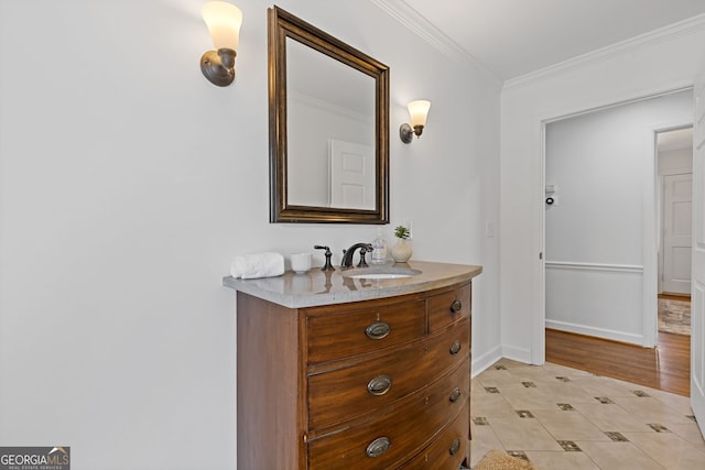 bathroom featuring baseboards, ornamental molding, and vanity