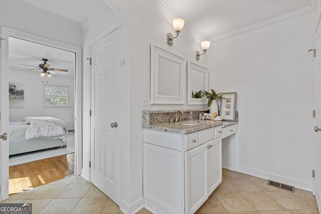 bathroom with tile patterned flooring, visible vents, a ceiling fan, and ornamental molding