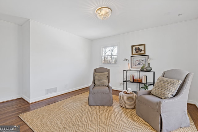 sitting room with visible vents, baseboards, and wood finished floors