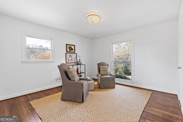 sitting room featuring baseboards, a healthy amount of sunlight, and wood finished floors