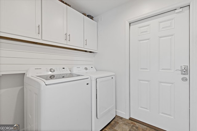 laundry room featuring baseboards, cabinet space, independent washer and dryer, and stone finish flooring