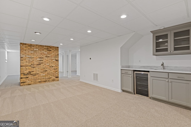 bar featuring beverage cooler, light colored carpet, wet bar, and baseboards