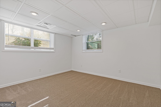 spare room featuring a wealth of natural light, baseboards, and carpet