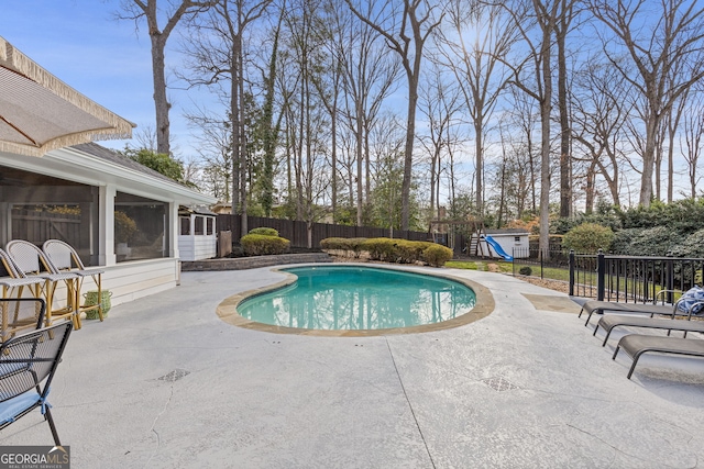 view of swimming pool featuring a patio area, a fenced in pool, a playground, and a fenced backyard