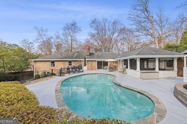 view of pool featuring a fenced in pool, a sunroom, fence, and a patio area